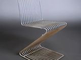 a close up of a metal chair on a gray surface