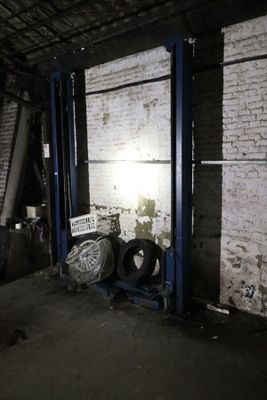 une photo d'un garage avec de nombreux pneus posés par terre