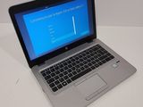 a laptop computer sitting on a table with a blue screen
