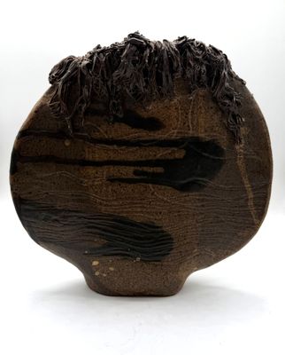 a wooden sculpture of a man ' s head on a white surface