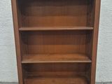 une vieille bibliothèque en bois surmontée de trois étagères