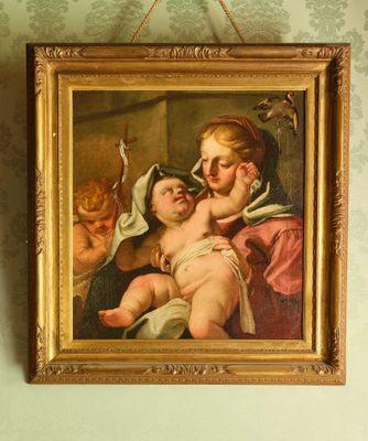 un tableau représentant une femme tenant un bébé dans ses bras, accroché au mur
