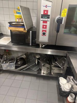 une cuisine professionnelle équipée de plans de travail et d'appareils électroménagers en acier inoxydable