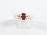 gros plan d'une bague en or avec un rubis et des diamants