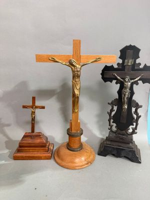 trois croix et un crucifix posés sur une table