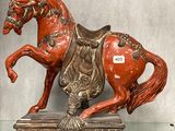 une statue représentant un cheval assis sur une table en verre