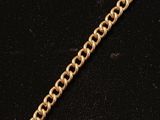 un bracelet à chaîne en or avec une breloque en forme de cœur