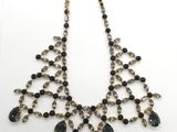 un collier imposant noir et doré orné de pierres noires
