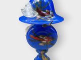 un vase bleu surmonté d'un oiseau