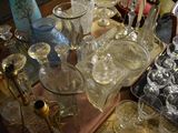 bottles and glasses on a table with a tray full of wine glasses