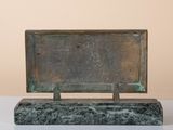 bronze sculpture of a rectangler on a marble base on a white surface