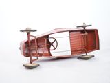 a red toy car that is sitting on a white surface