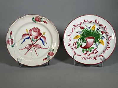 deux assiettes ornées de fleurs et d'oiseaux, posées sur un support