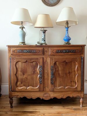 two lamps that are on top of a wooden cabinet