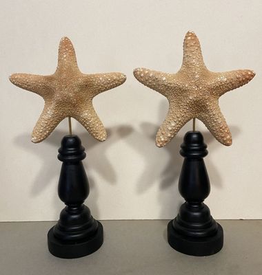 pair of starfish figurines sitting on top of a black table