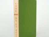 un livre vert posé sur une table blanche
