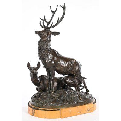 a bronze statue of a stag and two deers on a marble base