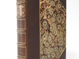 an old book with gears on it sitting on top of a white surface