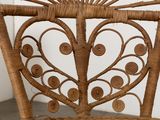 a wicker chair that has a heart shaped seat on it
