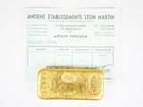 a gold bar sitting on top of a piece of paper