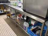 une cuisine équipée d'un plan de travail en inox et d'un réfrigérateur