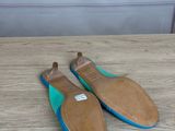 a pair of blue and brown shoes sitting on top of a wooden table