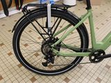 a green bike parked in a store with a basket on the back of the bike