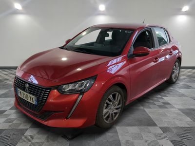 une voiture rouge garée dans un garage au sol en damier