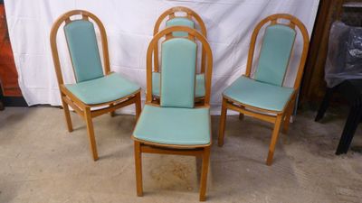three chairs with blue upholstered seats sit in front of a white backdrop
