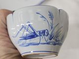 a hand holding a cup with a drawing of a grasshopper on it