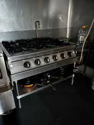 a stainless steel stove in a kitchen with a black floor