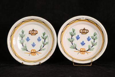 two plates with blue flowers and a crown on them on a black background