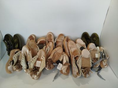 Plusieurs paires de chaussons de danse sont alignées dans une boîte blanche