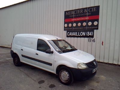 une petite camionnette blanche garée devant un bâtiment