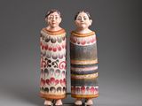 pair of ceramic figurines of a man and a woman standing next to each other