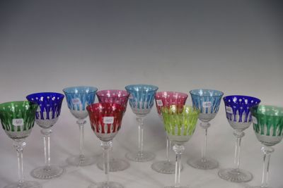 une rangée de verres à vin de différentes couleurs alignés sur la table