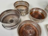 five silver dishes on a table with a spoon and a spoon rest