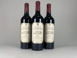 trois bouteilles de vin rouge sont alignées sur une table