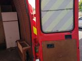 a red van with its door open in a parking lot