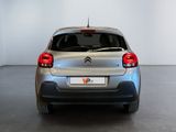 the rear end of a silver citrole parked in a white room