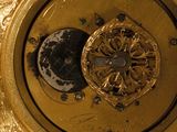 a close up of a gold clock on a table