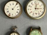 Quatre types différents de montres de poche sont exposés sur un support gris.