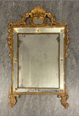 a mirror hanging on the wall with a gold frame