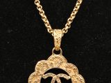 un collier en or orné d'une fleur et d'une chaîne, porté par un mannequin