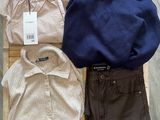 trois paires de pantalons, un pull et une chemise sont posés sur une chaise