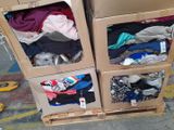 three boxes with clothes in them sitting on a pallet