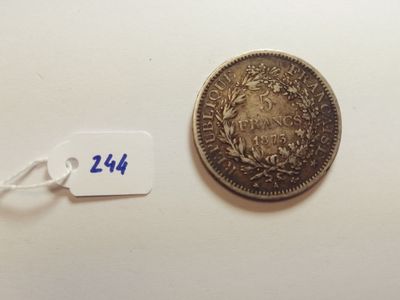 a silver coin with a tag on it next to a white tag