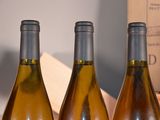four bottles of wine are lined up on a table