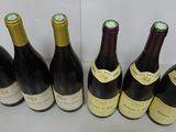 six bottles of wine are lined up in a row on a table
