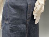 a mannequin wearing a white shirt and blue denim skirt